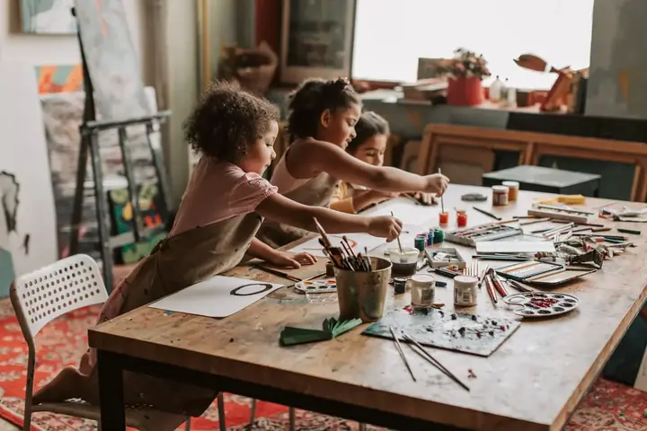 A child's hands covered in bright paint during a kindergarten craft activity