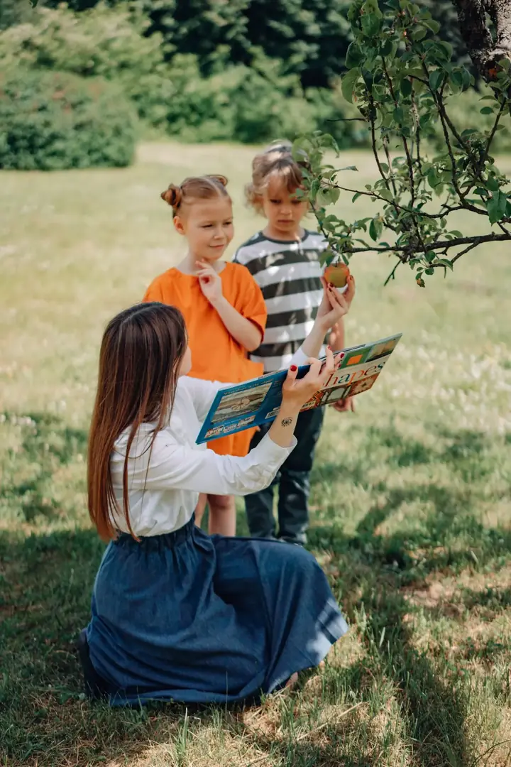 A kindergarten teacher reading a story to engaged children